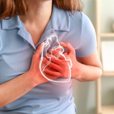 Young woman pressing on chest with painful expression. Severe heartache, having heart attack or painful cramps, heart disease.